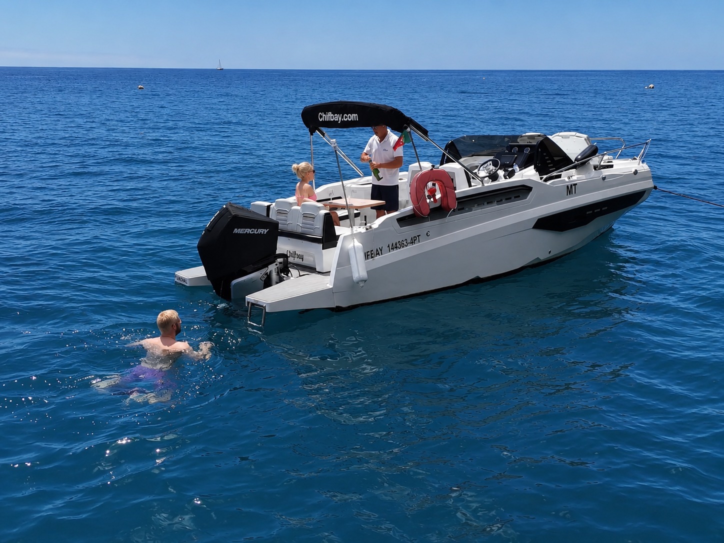 A guest swimming beside the Chifbay boat in clear water off Madeira
