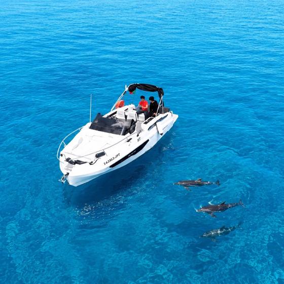 Chifbay's private boat anchored over clear turquoise water off Madeira, guests swimming alongside